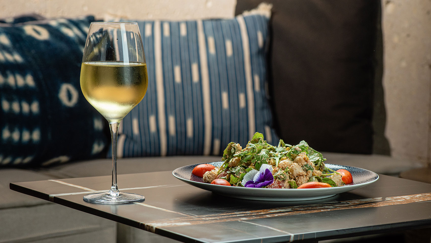 a glass of wine next to a plate of foods