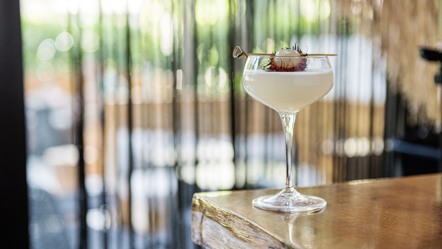 a glass of white wine with a fruit on top