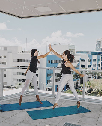 women doing yoga on terrace